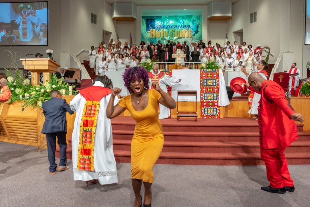 Bishop Davenport leads worshippers dancing in praise.